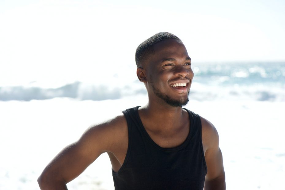 Happy young african american man smiling at the beach